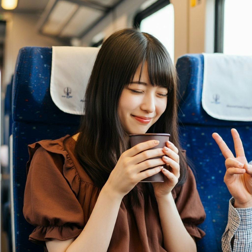 新幹線でコーヒーを飲む女性